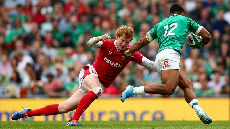 Wales’ Rhys Patchell goes to tackle Ireland’s Bundee Aki. Photo: James Crombie/Inpho