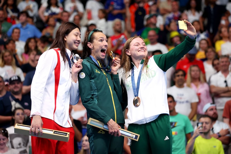 Mona McSharry of Ireland takes a selfie along with gold medal winner Tatjana Smith of South Africa and silver medallist Tang Qianting of China on the podium during the medal ceremony. Photograph: Sarah Stier/Getty Images