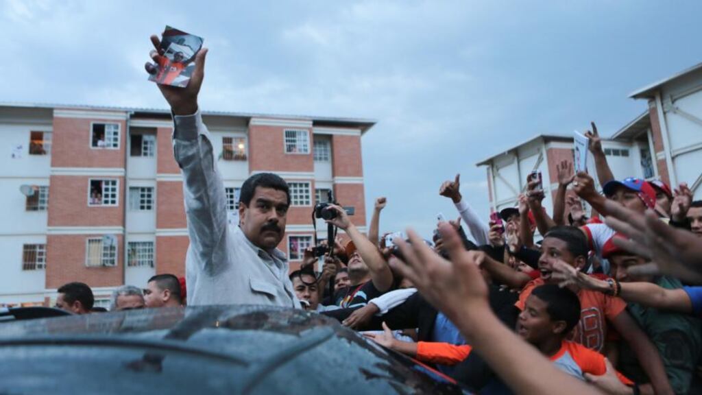 Venezuela’s president-elect Nicolas Maduro holds up a photograph of Jose Luis Ponce, a supporter killed on Monday's post-election street violence. Photograph: Marcelo Garcia/Reuters