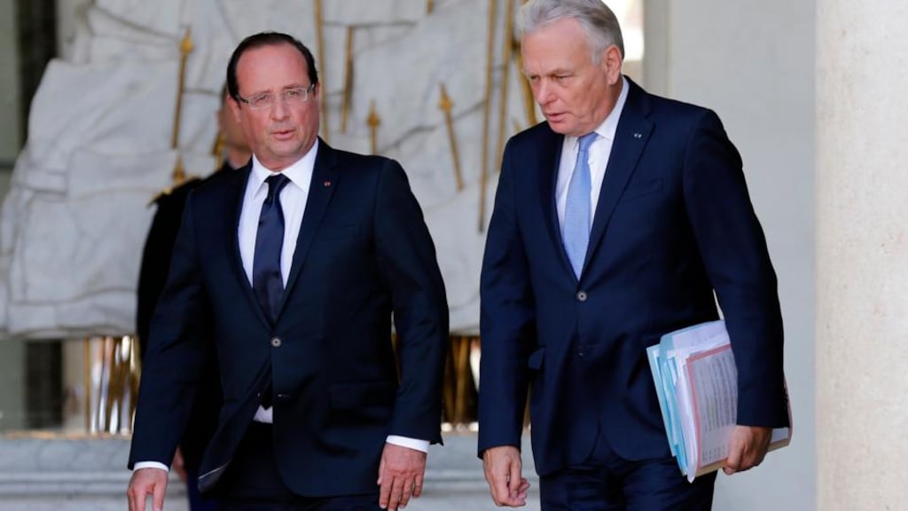 French President Francois Hollande (L) escorts France’s Prime Minister Jean-Marc Ayrault at the Elysee Palace in Paris after the government seminar.