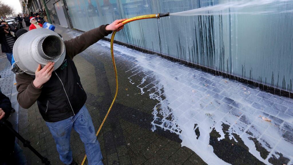 A dairy farmer sprays milk outside the MR political party during a demonstration in Brussels, Belgium . Photograph: Yves Herman /Reuters