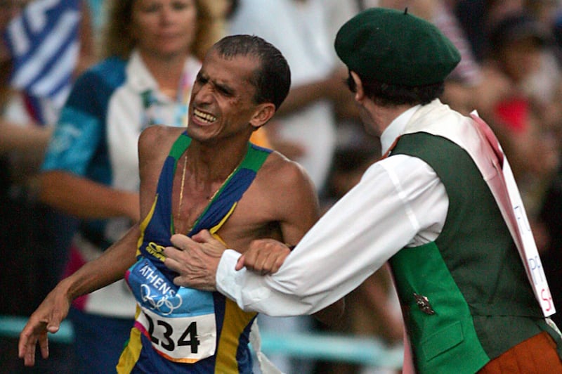 Vanderlei Lima is pushed by Cornelius Horan, a defrocked Irish priest, in the latter stages of the marathon at the Olympic Games in Athens in 2004. The Brazilian's bid for gold was derailed and he eventually finished third, claiming a bronze medal. Photograph: Jiro Mochizuki/AFP/Getty Images