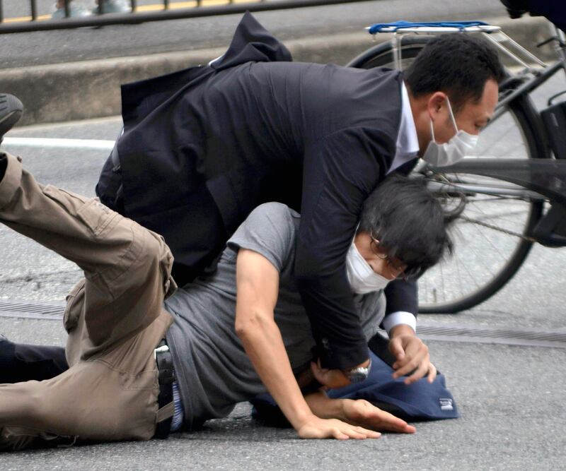 Tetsuya Yamagami, bottom, is detained after Mr Abe’s shooting. Photograph: Katsuhiko Hirano/The Yomiuri Shimbun/AP