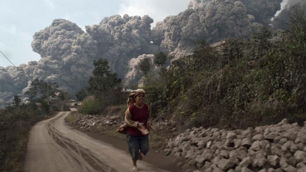A villager runs as Mount Sinabung erupts at Sigarang-Garang village in Karo district, Indonesia’s North Sumatra province today. Photograph: Reuters