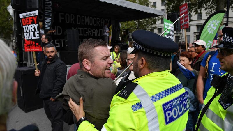 Police restrain a demonstrator shouting at people attending the anti-government protest. Photograph: Daniel Leal-Olivas/AFP/Getty