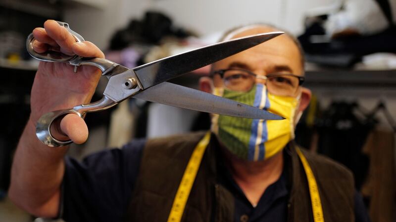 Tailor Yalcine of Boulard Retouche displays his fetish scissors he uses to cut cotton face masks in his shop in the Daguerre district of Paris. Photograph: Francois Mori/AP