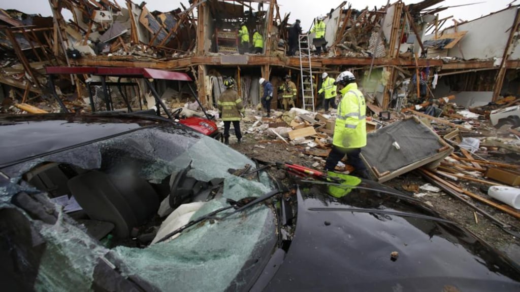 A destroyed car sits as firefighters conduct a search and rescue of an apartment complex destroyed by an explosion at a fertilizer plant in the town of West, Texas. Photograph: AP Photo/LM Otero