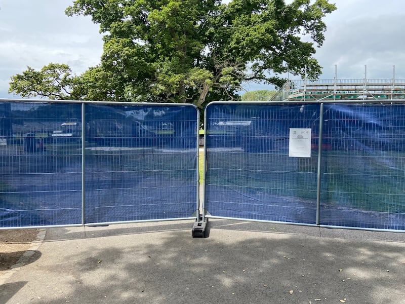 A view of the security railings outside of Malahide for Ireland's games against India. The blue tarpaulin does not completely obscure a view of the pitch while there are gaps in the railings accessible from the grounds of Malahide Castle.