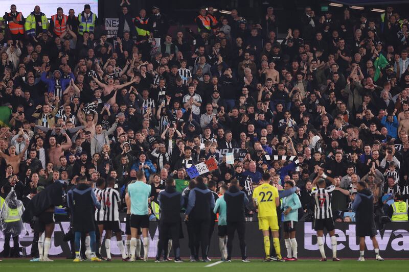 Newcastle United players and fans after their victory at West Ham, oblivious to a truculent cockney statue of liberty. Photograph: Alex Pantling/Getty Images