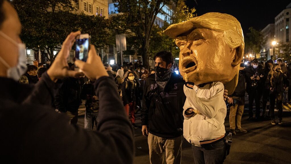 A man poses for a photograph with a man dressed as US president Donald Trump at the Black Lives Matter Plaza in Washington DC. Photograph: Chris McGrath/Getty Images