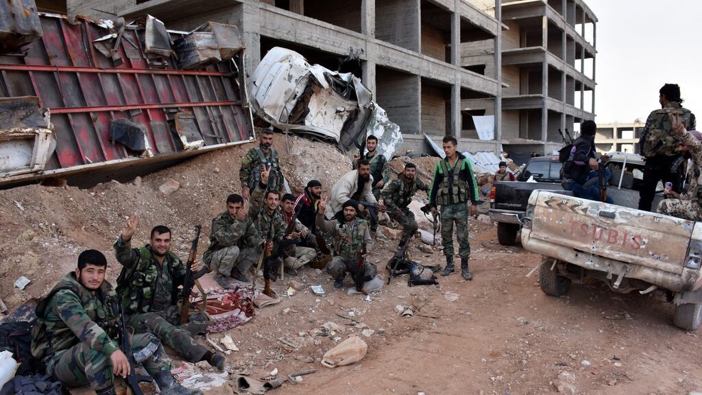 Syrian soldiers take a rest after they liberated the 1070 Apartment area in Aleppo province. Photograph: EPA