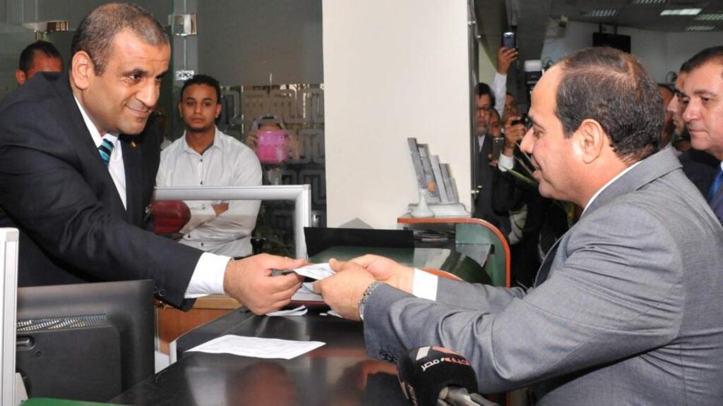 Egyptian president Abdel-Fattah al-Sisi (right) making a donation to a fund to support the Egyptian economy at a bank in Cairo earlier this month. Sisi had just announced cuts to subsidies in an attempt to improve the economy. Photograph: Egyptian presidency/EPA