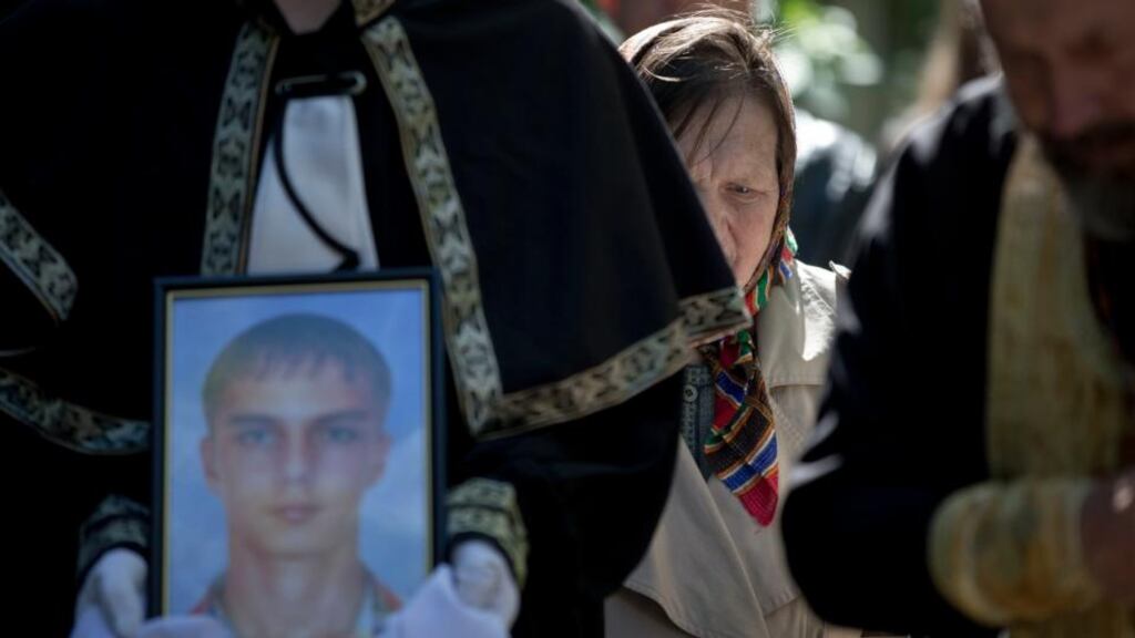 A funeral steward holds a picture of 17-year-old Vadim Papura during a religious service in Odessa yesterday. Photograph: AP Photo/Vadim Ghirda