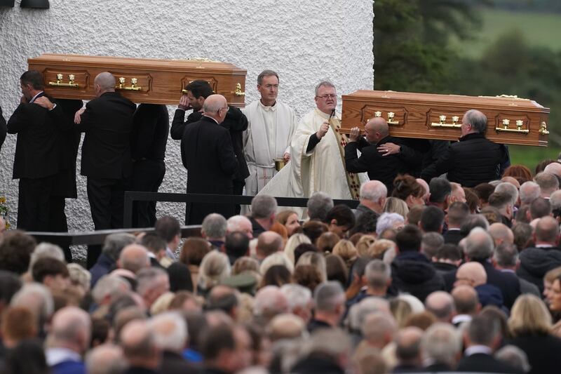 Priest Fr John Joe Duffy sprinkles holy water on the coffins of James Monaghan and his mother Catherine O'Donnell as they are carried into St Michael's Church, Creeslough for their funeral Mass. Photograph: Brian Lawless/PA