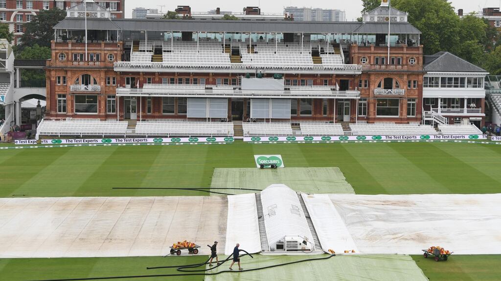 Head groundsman Mick Hunt (bottom right) works on the covers at Lord’s. Photograph: Stu Forster/Getty Images