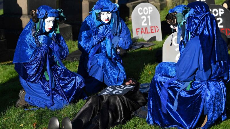 Performers from the Blue Rebels conduct a funeral ceremony at Glasgow Cathedral to symbolise what they call a failure of the Cop26 process. Photograph: Paul Ellis/AFP via Getty