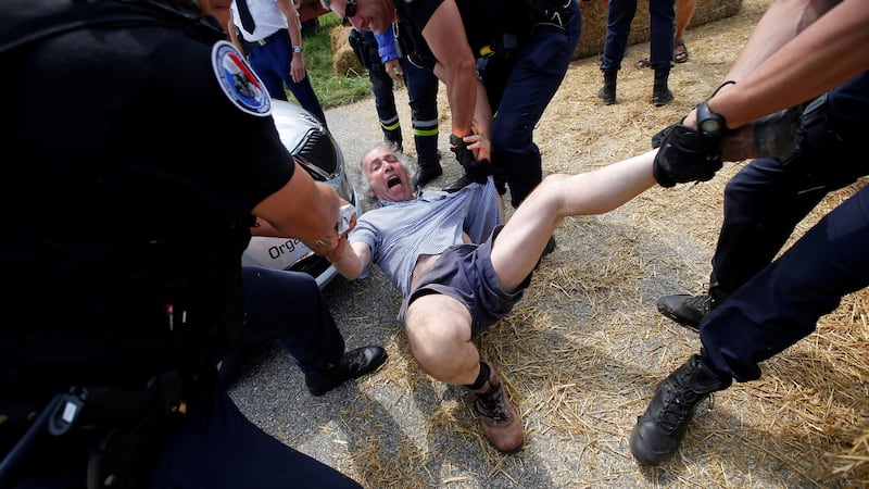 Police officers carry a protester off the road. Photo: Stephane Mahe/Reuters