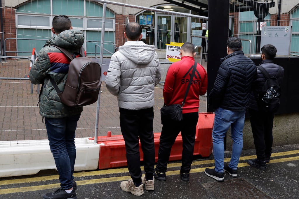 Men queue outside the International Protection Office, Mount Street, Dublin, where applications for asylum are made. The owners of a company that received almost €20 million last year from the State for accommodating asylum seekers and Ukrainian refugees have been convicted of tax offences. Photograph: Conor Ó Mearáin/Collins