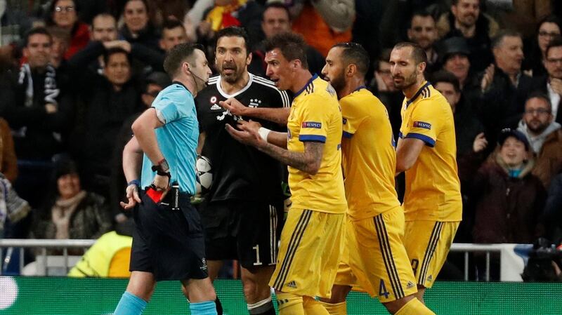Buffon and teammates remonstrate with referee Michael Oliver after he awarded a penalty to Real Madrid. Photo: Paul Hanna/Reuters