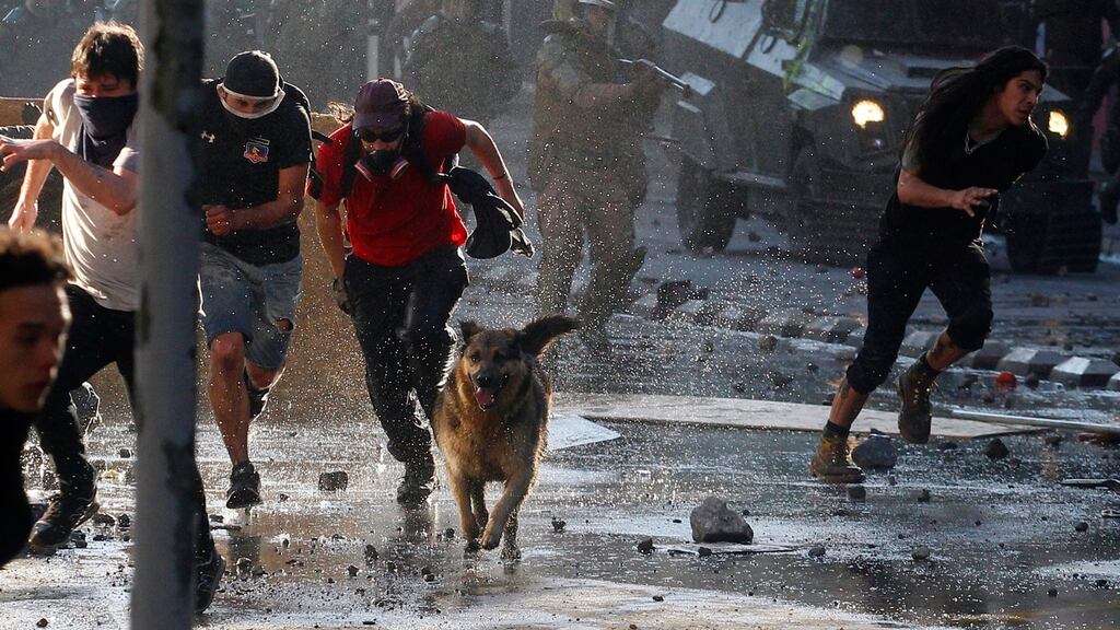Anti-government demonstrators clash with police as they protest against cost of living increases in Santiago, Chile. Photograph:  Marcelo Hernandez/Getty Images
