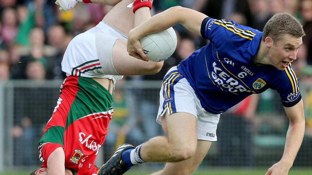 Mayo’s Lee Keegan takes a tumble as Kerry’s Peter Crowley makes off with the ball during the replayed All-Ireland semi-final at the Gaelic Grounds, Limerick. Photo: Donall Farmer/Inpho