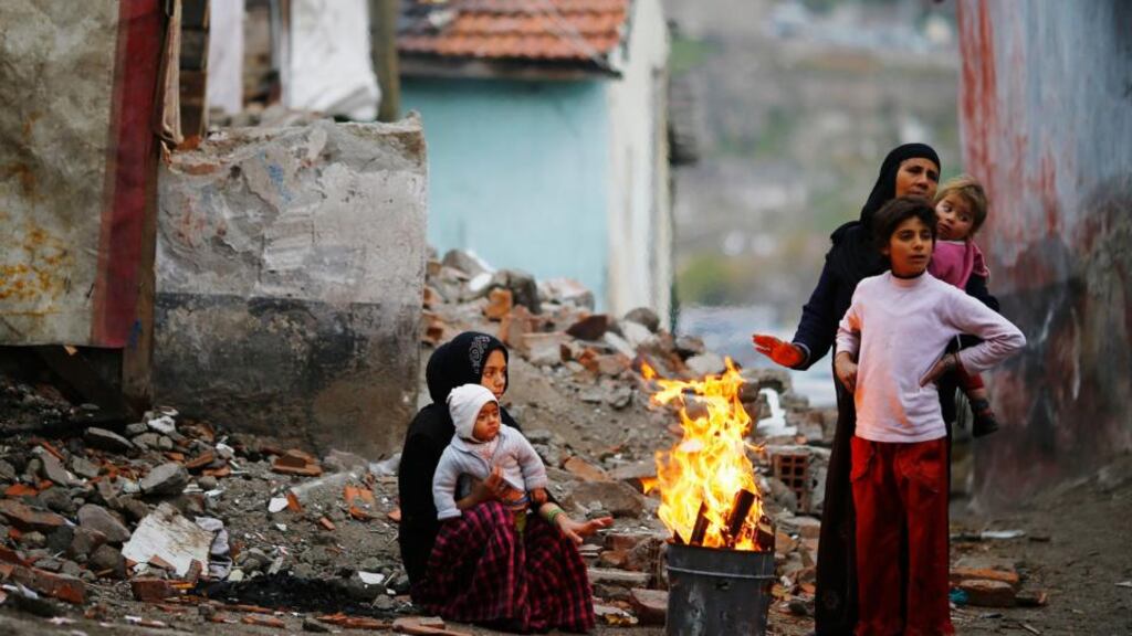 Teifigh ón tSiria cois tine. grianghraf: reuters