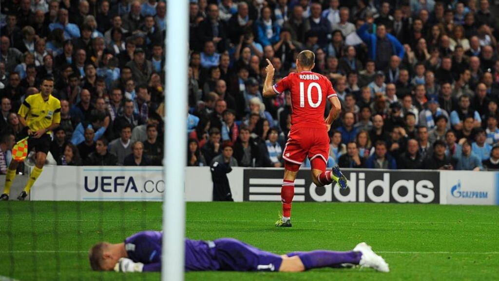 Manchester City goalkeeper Joe Hart lies dejected as Bayern Munich’s Arjen Robben celebrates scoring his side’s third goal of the game during the UEFA Champions League match at the Etihad Stadium in Manchester. Photograph: Martin Rickett/PA Wire