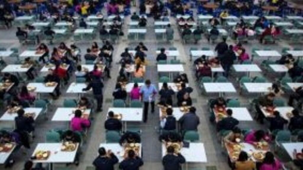 Workers eat their lunch at a restaurant inside a Foxconn factory in the township of Longhua in Shenzhen, Guangdong province in China. At present the company employs roughly a million workers across the country.
