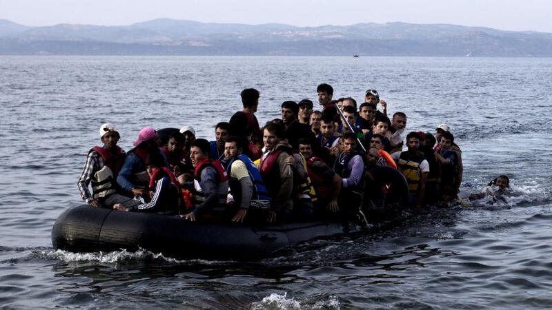 Refugees and migrants arriving on the shores of the Greek island of Lesbos after crossing the Aegean Sea from Turkey on an inflatable boat. Photograph: Angelos Tzortzinis/AFP/Getty Images