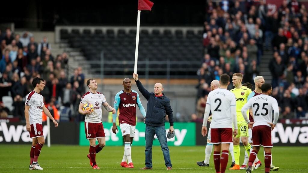 A fan holds up a corner flag after invading the pitch during the game between West Ham and Burnley at the London Stadium. Photograph: David Klein/Reuters