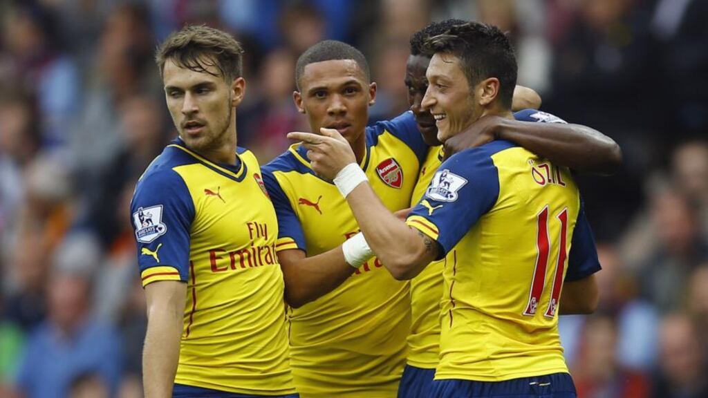 Arsenal’s Mesut Özil (right) celebrates with teammates after scoring against Aston Villa at Villa Park. Photograph: Darren Staples / Reuters