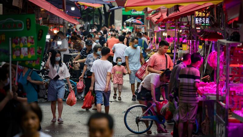 A man leads a child by the hand at a market in Guangzhou, China. Photograph: Qilai Shen/The New York Times