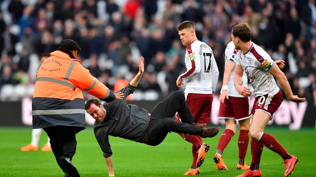 Burnley’s Ashley Barnes trips up a pitch invader at The London Stadium last weekend. Photograph: Getty Images