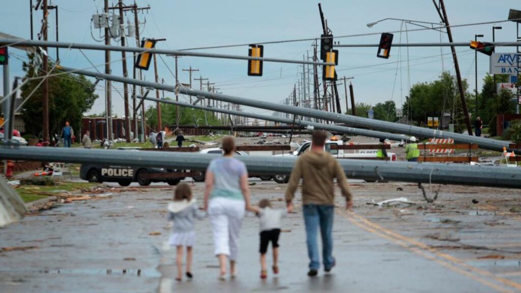 Downed utility poles block the road as a family walks south on Sante Fe Avenue in Moore, Oklahoma. Photograph: Brett Deering/Getty Images