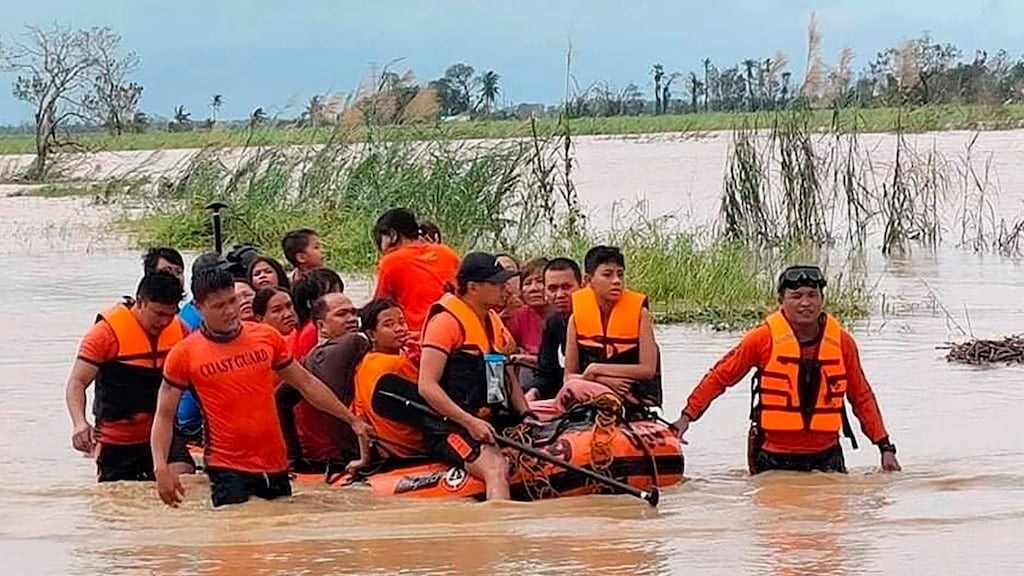 Rescuers pull a rubber boat as they assist residents who were trapped in their homes. Photograph: Philippine Coast Guard via AP