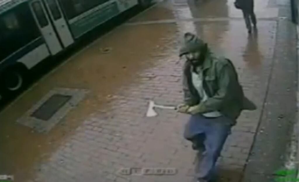 A screengrab from CCTV video of a hatchet-wielding attacker charging a group of New York City police officers yesterday.