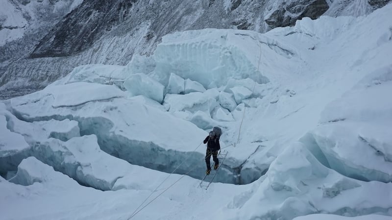 Rory McHugh crossing a crevasse Rory crossing a ladder in the icefall.