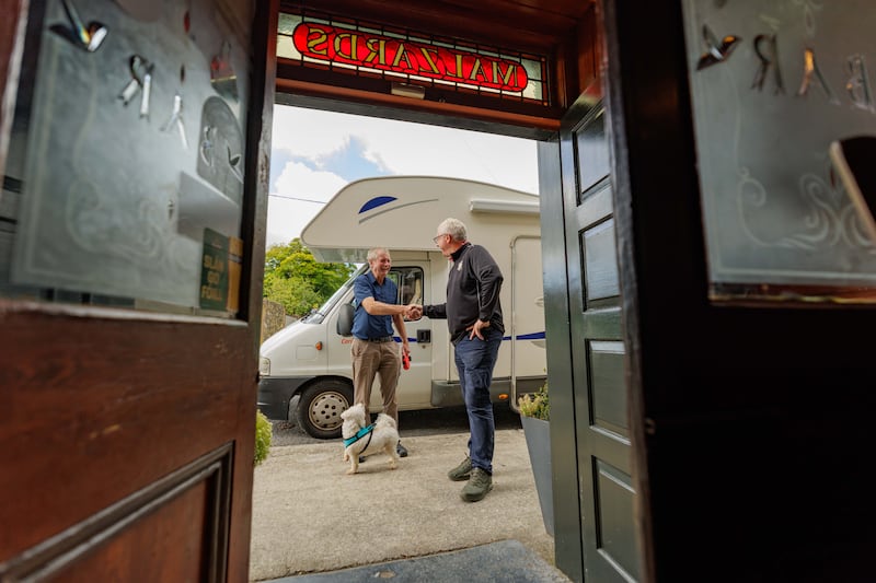 Fred Malzard, right, greets Tom Whelan from Kilmacthomas, Co Kilkenny, and dog Charlie to Malzards pub and camper van site. Photograph: Dylan Vaughan