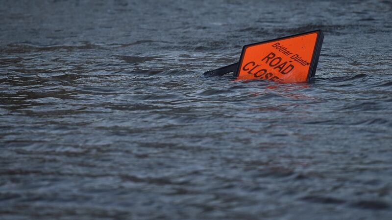 A ‘road closed’ sign is seen submerged in floodwater during Storm Ophelia in Galway. Photograph: Clodagh Kilcoyne/Reuters