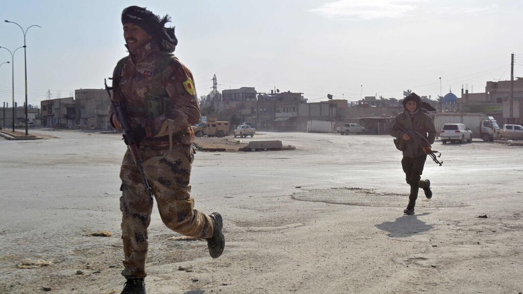 Syrian Democratic Forces (SDF) cross a street in the northern Syrian city of al-Hasakah. Photograph: Delil Souleiman/AFP via Getty Images