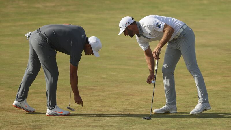 Koepka and Dustin Johnson look at a pitch mark on the 15th green. Photo: Streeter Lecka/Getty Images