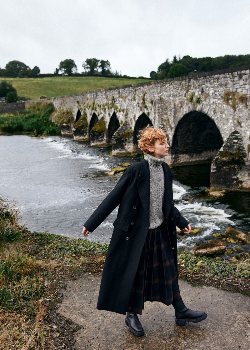 Black double-breasted coat, €649, and tweed knit polo neck, €167, Fisherman out of Ireland; check boiled wool pleated skirt, €520, Dawei at Beautiful South, Rathmines