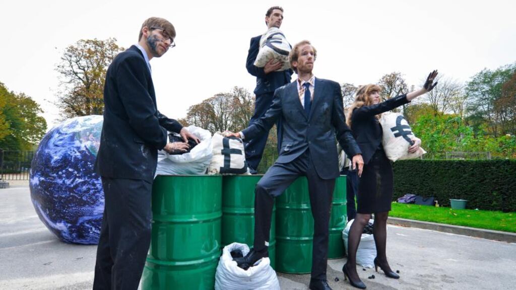 Environmental activists dressed up as corporate lobbyists protest at the European summit in Brussels where government leaders are meeting for negotiations on climate targets. Photograph: EPA