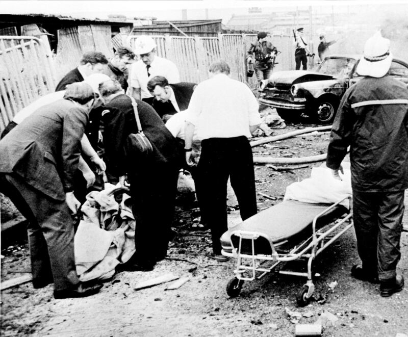 Rescue workers lift the remains of a body into a polythene bag after an explosion in Belfast on Bloody Friday
