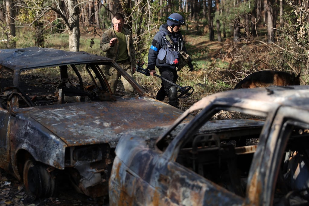 Ukrainian servicemen walk past burnt civilian vehicles on a road near Izyum in the Kharkiv region, where Irishman Roy Mason was killed while fighting with the International Legion for the Defence of Ukraine. Photograph: Anatolii StepanovAFP via Getty