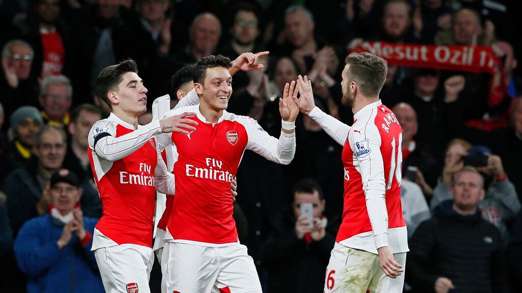 Arsenal’s Mesut Ozil celebrates scoring their second goal with Hector Bellerin and Aaron Ramsey. Photograph: Stefan Wermuth/Reuters