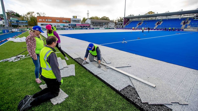 Volunteers help in laying the hockey pitch at Energia Park in Donnybrook ahead of the women’s Olympic qualifier matches this weekend. Photograph: Morgan Treacy/Inpho