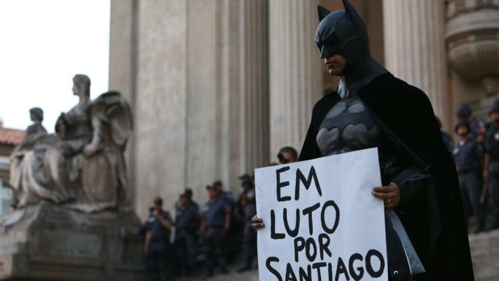 A demonstrator in Rio de Janeiro shows a placard that says: ‘Mourning for Santiago’ during a protest against an increase in public transport ticket prices. The death of TV cameraman Santiago Andrade during an earlier protest shocked Brazil, but the political class has seized its chance to criminalise protest ahead of the World Cup. Photograph: Marcelo Sayao/ EPA