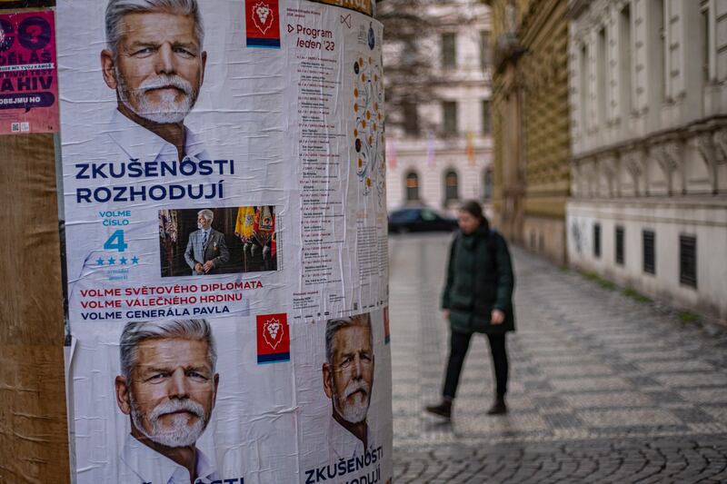 A woman walks by election posters of Czech presidential candidate Petr Pavel in Prague. Photograph: Martin Divisek/EPA-EFE