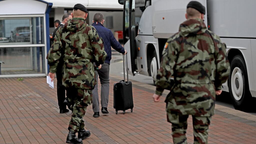 A passenger is escorted to a bus to be taken to the Crowne Plaza hotel: The public was tricked into believing quarantine would lead to a loosening of our current exhausting lockdown. Photograph: Donall Farmer/Getty